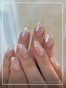 Detail of aurora pink press-on nails with iridescent glitter and gold foil accents