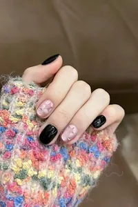 Close-up of pink cat-eye press-on nails with star patterns and sparkling rhinestones