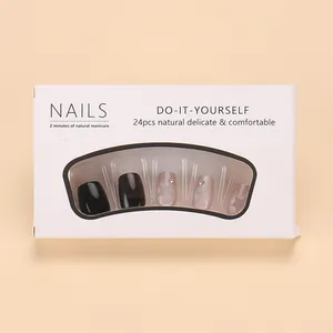 Close-up of black and pink press-on nails with star patterns in premium packaging box