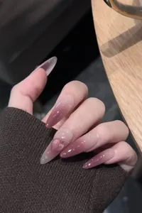 Detail of long almond press-on nails with purple gradient and 3D heart diamond accent