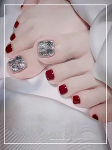 Macro view of dark burgundy press-on toenails with square rhinestones for summer