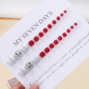 Glossy deep red and silver glitter press-on toenails set with square rhinestone accents