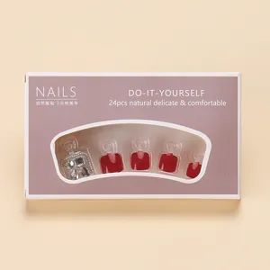 Deep red press-on toenails with rhinestone accents in 24-piece purple packaging