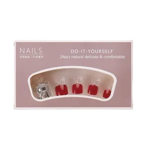 Glossy deep red press-on toenails set with rhinestone accents in a 24-piece retail box
