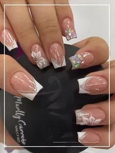 Macro detail of French press-on nails with 3D floral accents and glitter silver outlines