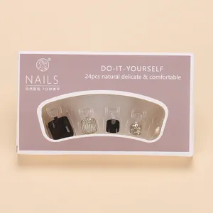 Detalle de 24 uñas postizas para pies en negro y dorado brillante con estuche morado