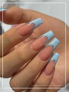 Detail of French press-on nails with blue tips and silver glitter on long coffin shape
