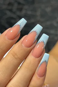 Macro detail of French blue tipped coffin press-on nails with silver glitter accents