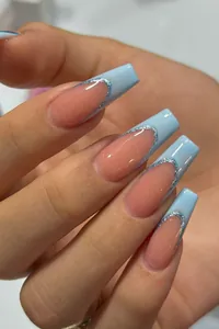 Macro view of blue French tip coffin press-on nails with silver glitter outline detail