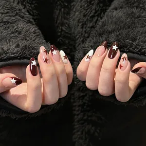 Détail de faux ongles amande avec motifs étoilés bordeaux, ivoire et rose poudré