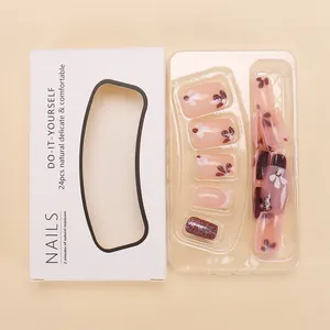 Faux ongles courts avec base rose nude, fleurs violettes pailletées et motifs floraux blancs