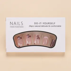Faux ongles courts carrés avec motifs floraux roses et paillettes violettes en boîte