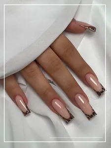 Close-up of nude square press-on nails with leopard print French tips on white silk