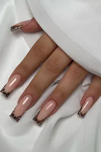 Macro detail of French leopard print square press-on nails on white silk fabric