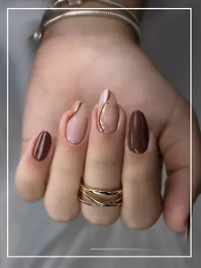 Dettagli di unghie finte sfumate caffè e nudo con texture marmo e glitter dorati