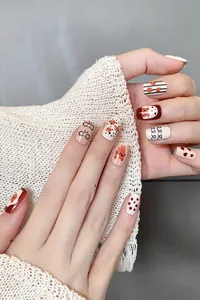 Detailed view of short round press-on nails with cartoon bear and pearl embellishments