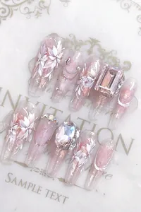 Detailed view of handmade press-on nails with pink gems and floral nail art designs