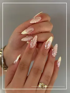 Detail showing French yellow shell line press-on nails with 3D relief texture and pearls