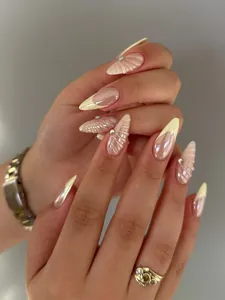 Detail of almond-shaped press-on nails with 3D shell texture and yellow French tips
