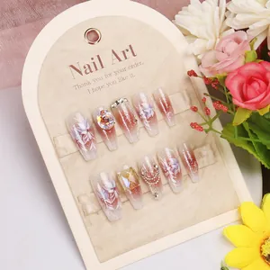 Handmade cat-eye press-on nails with floral patterns, rhinestones, and pearls