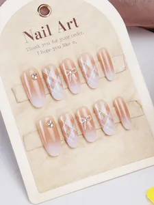 Λεπτομέρεια από nude pink cat-eye νύχια με καρό σχέδια και 3D διακοσμητικούς φιόγκους