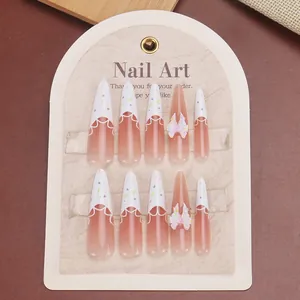 Handmade stiletto press-on nails with pink gradient, French tips, and 3D bow accents