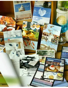 Cartes postales illustrées avec chats et paysages sur un support en bois chaleureux