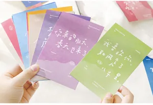 Cartes de vœux illustrées tenues à la main sur un fond de tissu blanc doux et épuré