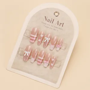 Pink French bow and heart press-on nails with 3D crystal accents on white card