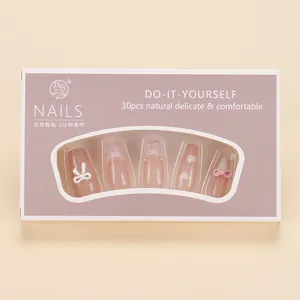 Detail of pink heart and bow press-on nails set with glitter and 3D relief accents