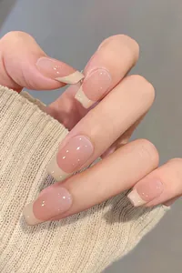 Détail des faux ongles French avec dégradé nude et pointes blanc crème élégantes