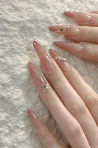 Nahaufnahme von rosa Ombré Stiletto Kunstnägeln mit Strasssteinen und Perlen