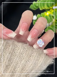 Macro detail of French press-on nails with 3D shell flower and pearl jewelry accents