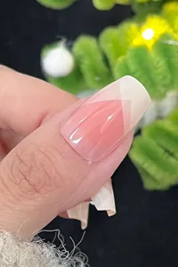 Macro view of pink French press-on nail with white geometric tip and glossy finish
