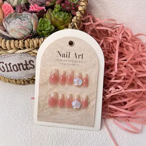 Pink gradient coffin fake nails with white 3D floral accents and geometric patterns