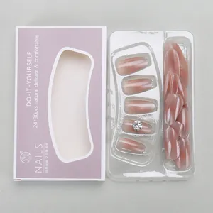 Detail of gradient pink purple press-on nails with sparkling rhinestones in a purple box