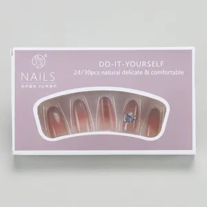 Detail of pink cat-eye press-on nails set with rhinestones in purple window box