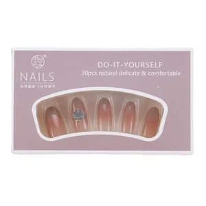 Pink cat eye gradient press-on nails with rhinestone accents in a 30-piece box set