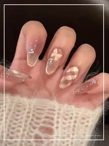 Close-up of pink cat eye press-on nails with 3D butterflies and rhinestone details