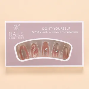 Detail of pink-brown gradient press-on nails with cat eye finish and rhinestones