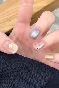 Détail de faux ongles œil-de-chat avec paillettes argentées, étoiles et points rouges