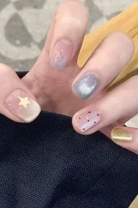Détail de faux ongles œil-de-chat avec paillettes argentées, dégradé violet et étoiles