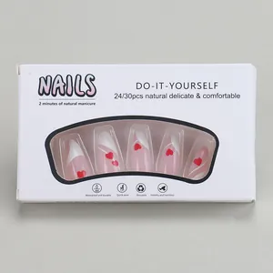 Detail of French tip press-on nails with red heart patterns in a 24-piece display box
