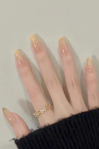 Macro shot of gold butterfly ring with rhinestones and sparkling glitter fake nails