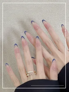 French blue tipped almond press-on nails with soft pink base on model hand