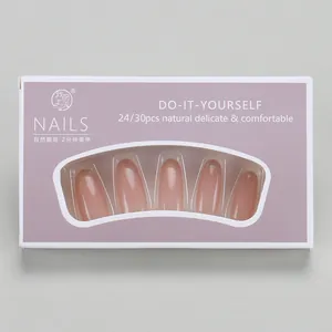 Macro view of French gradient press-on nails with gold glitter in purple retail box