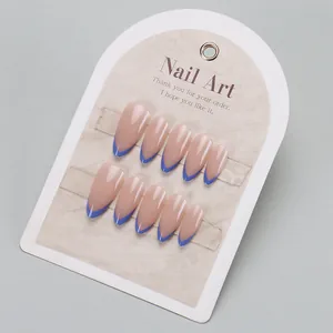 Long pointed French tip press-on nails in nude pink and royal blue on a white display card