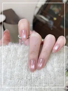 Close-up of nude pink cat eye press-on nails with shimmering pearlescent finish