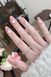 Close-up of pink gradient cat-eye press-on nails with a silver beaded ring detail