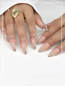 Macro detail of almond press-on nails with nude base and silver metallic French tips